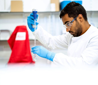 Man In Lab Using Serological Pipette to Dispense Liquids into Centrifuge tube